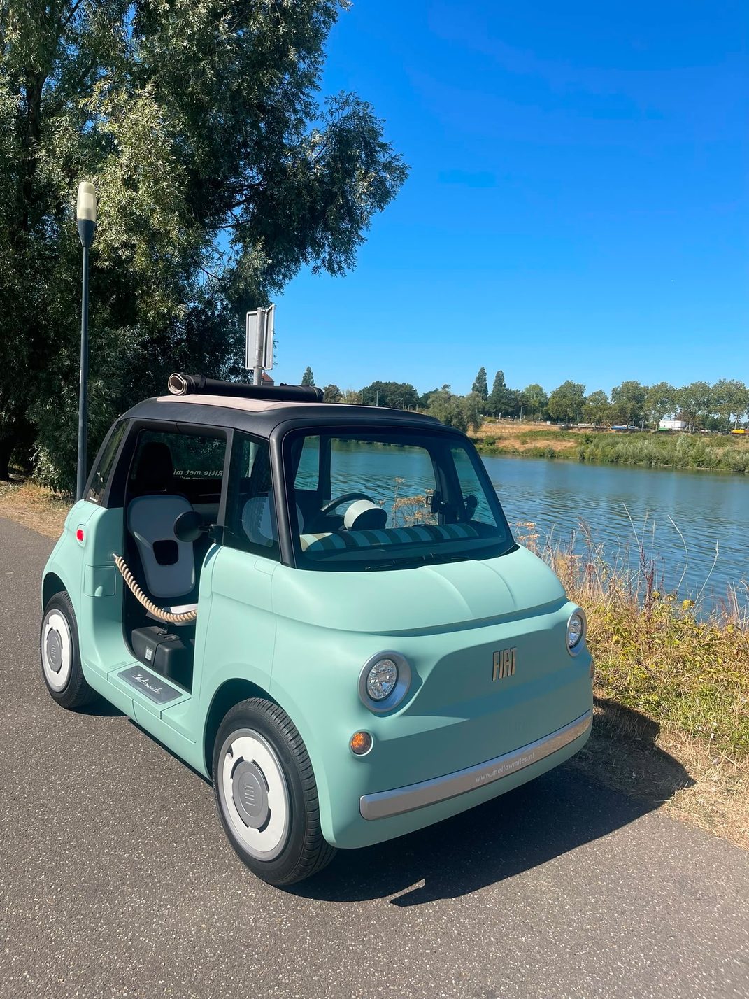 Mintgroene Fiat Topolino geparkeerd aan de Maas in Noord-Limburg